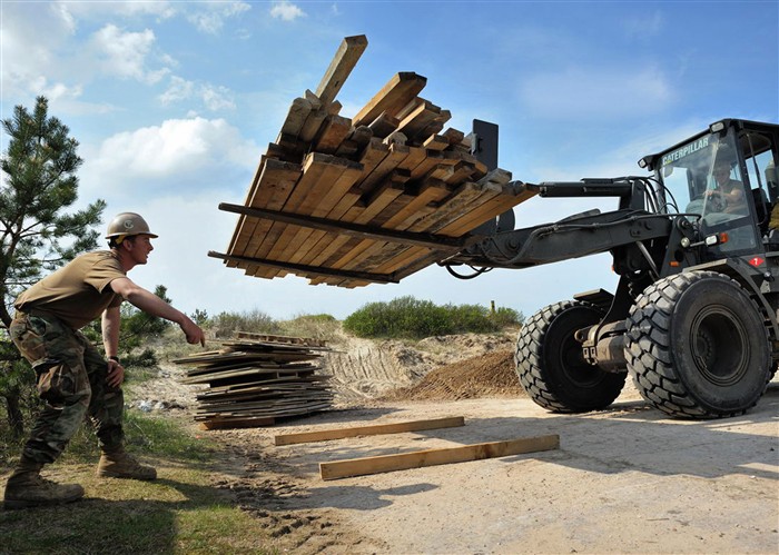 VENTSPILS, Latvia (May 18, 2010) Builder 3rd Class Justin O&#39;Donnell, assigned to Naval Mobile Construction Battalion (NMCB) 7, guides Equipment Operator 3rd Class Zachary Bunter as he operates a caterpillar 924G bucket loader to stage timber for wall forms in Ventspils, Latvia, supporting Baltic Operations (BALTOPS) 2010 May 18. NMCB-7 and its detachments are deployed to various locations throughout the U.S. 6th Fleet area of responsibility. (U.S. Navy photo)