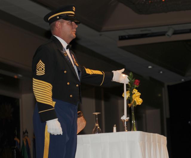 HONOLULU, Hawaii-Command Sgt. Maj. Joseph Zettlemoyer, command sergeant major, U.S. Army-Pacific identifies the single rose, symbolic of families and loved ones who keep faith awaiting the return of prisoners of war and those missing in action at an empty table honoring them during the 235th Army Birthday Commemoration, at the Hilton Hawaiian Village, here, June 12.