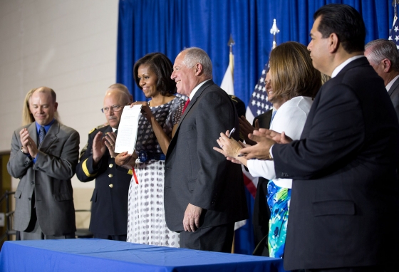 First Lady Michelle Obama holds the “Military Family Licensing Act,” signed by Illinois Gov. Pat Quinn (June 26, 2012)