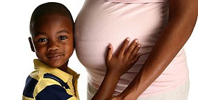 boy resting head on pregnant stomach