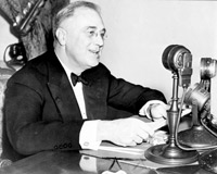 Franklin Delano Roosevelt at a microphone.