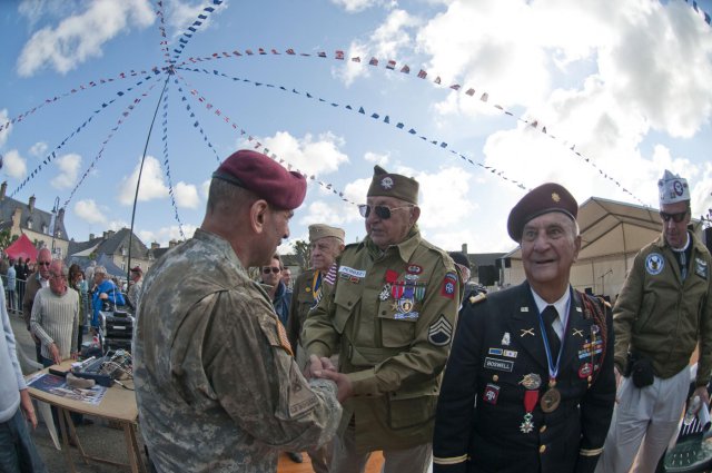 Maj. Gen. Jeffrey Jacobs, U.S. Army Civil Affiars & Psychological Operations Command (Airborne) commanding general, shakes hands with World War II and D-Day veteran, John Perozzi, 82nd Airborne Division, after a ceremony honoring him and other World War II veterans, June 3, 2012. Task Force 68, which is made up of paratroopers from U.S., Germany, France, Holland, and United Kingdom, re-enacted the D-Day airborne operation on the La Fiere fields near Ste. Mere Eglise, France to commemorate the heroic acts of the WWII paratroopers who made the jump 68 years ago. After the jump, the task force marched into the town of Ste. Mere Eglise to the sounds of cheers from the locals. Task Force 68 is in Normandy, France, to commemorate the 68th anniversary of D-Day.