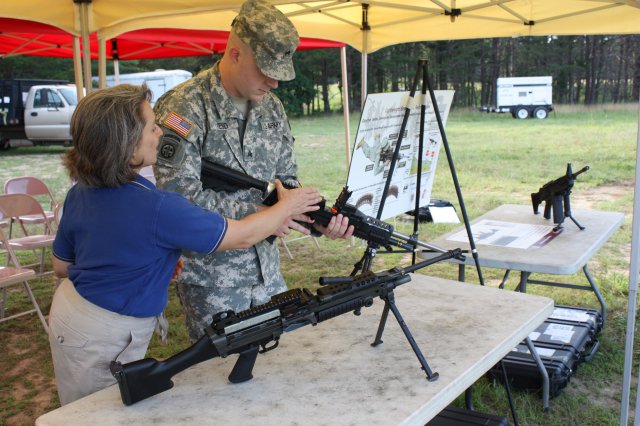 Kori Phillips, an ARDEC systems management engineer, talks to Sgt. Jason Reed about the chamber of the lighter version of the M249 machine gun.