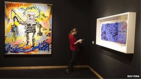 A woman stands between Jean-Michel Basquiat's Untitled 1981 and Yves Klein's Accord Bleu (Relief Eponge) 1958