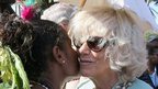 Camilla, Duchess of Cornwall. is given a kiss by a 24-year-old dancer Jenny Lohia as she is presented with a traditional necklace during a visit to Borea Village 