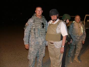 Carter witjh a soldier while awaiting a black hawk helicopter at night in Balad, Iraq