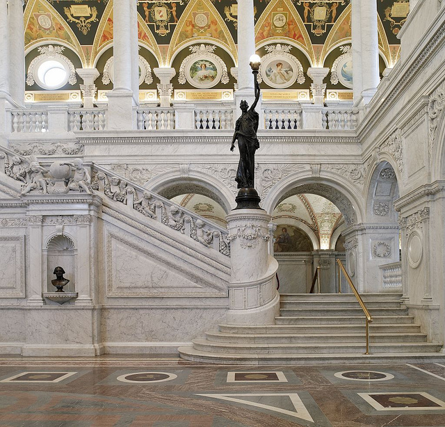 [Great Hall. View of grand staircase and bronze statue of female figure on newel post holding a torch of electric light, with bust of George Washington at left. Library of Congress Thomas Jefferson Building, Washington, D.C.] (LOC)