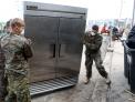 Marines move a large appliance