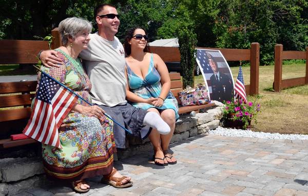 Jesse Reed's mother, Dolores (left), sits with Reed's best friend, Adam Keys, and Reed's wife, Heather on a bench dedicated to Reed's memory along the Ironton Rails to Trails.