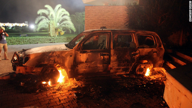 A vehicle sits smoldering in flames on Tuesday.