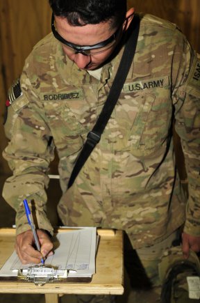 Specialist Andy Rodriguez, a motor transport operator with A Company, 209th Aviation Support Battalion, 25th Combat Aviation Brigade, signs in at the First Cup on Mustang Ramp as he drops off some care packages for other Soldiers to use on Kandahar Airfield, Afghanistan, March 13.