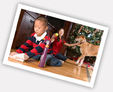 Photo of young boy at home cleaning with a girl and dog playing in the background