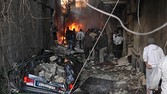 Syrian men inspecting the scene of a car bomb explosion in Jaramana, Damascus