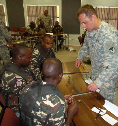 A U.S. Army Security Assistance Training Management Organization trainer uses toy soldiers to demonstrate the proper squad line formation to Namibian Defense Force soldiers during the Small Unit Tactics class. USASATMO's Engagement Branch Mobile Training Team conducted a Warrior Leader Instructor Training Course there as part of establishing a Namibian Noncommissioned officer training course.