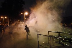 image: Protesters run away from tear gas as they try to remove barriers from outside the Egyptian presidential palace's main gate during a demonstration in Cairo on Dec. 4, 2012. 