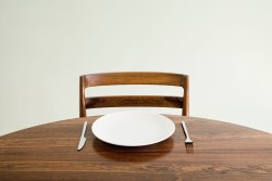 image: Empty plate with knife and fork on table