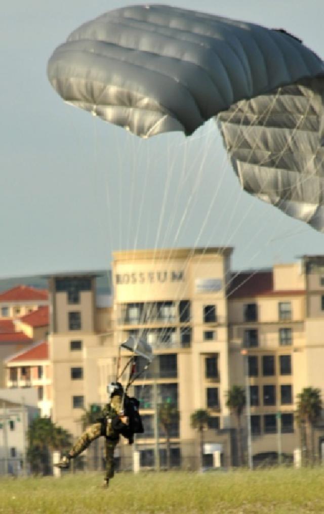 A New York Air National Guard Pararescueman (PJ) from the 103rd Rescue Squadron out of Suffolk County, lands during a demonstration at Air Force Base Ysterplaat, Cape Town, South Africa Sept 22.  More than 70 members of the New York Army and Air National Guard are participating in the Africa Aerospace and Defense Exposition 2010 which features aircraft from more than 30 countries.