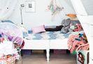 Modern kids room with white walls and bright textiles