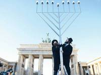 Glaubensbekenntnis. Gemeinsam haben die Rabbiner Yehuda Teichtal (rechts) und Shmuel Segal gestern auf dem Pariser Platz einen sechs Meter hohen Chanukka-Leuchter aufgestellt. Angezündet wird er aber erst am morgigen Sonntag um 18.30 Uhr. Foto: dpa