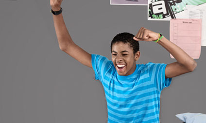 Teenager playing video games celebrating with arms in air