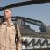 WO Joseph Walker stands next to an AH-64 Apache