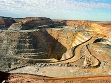 A deep opencut mine in which some roads can be seen, the dirt is a rusty colour