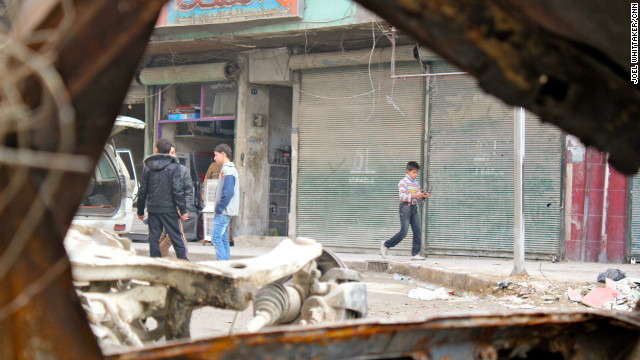 Boys walk through a damaged area In Aleppo, Syria, seen through a destroyed car on December 4.