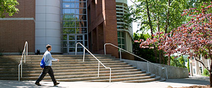 photo of man walking by steps and entrance to Dean Rusk Hall