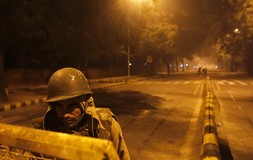 A policeman stands guard on a road to stop demonstrators from moving towards the India Gate in New Delhi December 24, 2012. Indian authorities throttled movement in the heart of the capital on Monday, shutting roads and railway stations in a bid to restore law and order after police...