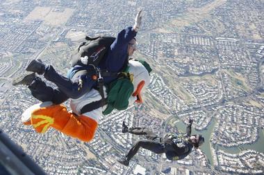 Holding tight to his lower bill, the Oregon Ducks mascot skydives from an airplane above Arizona on Wednesday. The event was part of preparations leading to Thursday's Fiesta Bowl game against Kansas State University.