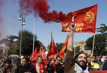 A worker from Italy's radical metalworkers union Fiom holds up a flare during an eight hour strike in Rome March 9, 2012. REUTERS/Max Rossi