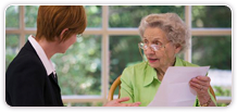 A woman speaking with a senior woman.