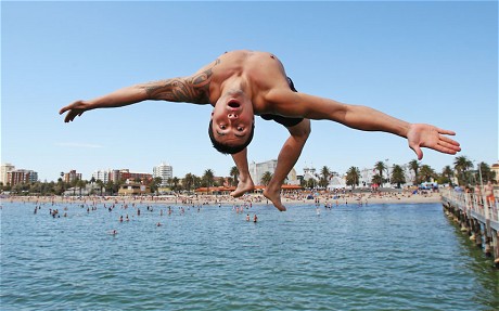 Jershon Witehira jumps into the water from a pier at St Kilda Beach  in Melbourne. Temperatures are expected to soar to above 40 degrees for several consecutive days in parts of Victoria and South Australia.