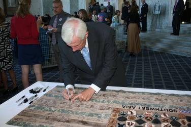 Signing a flag for our troops that will be sent to the USO center in Kandahar.