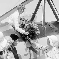 Amelia Earhart receives a bouquet of flowers upon arriving in Denver