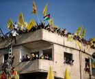 Palestinians stand atop a building as they take part in a rally marking Fatah's 48th anniversary.