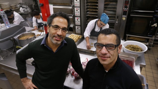 Chefs Yotam Ottolenghi, left, and Sami Tamimi, right, pose for the photographer at their company's bakery in London. (photo credit: AP/Lefteris Pitarakis)