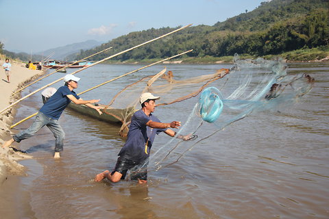 Fishermen hurling nets along the banks of the Mekong in northern Laos.