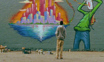 Teenager spraypainting a mural on a large brick wall