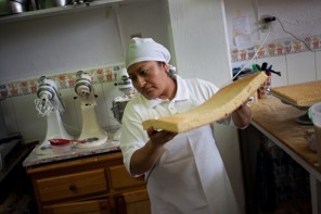 Angelica Espinosa works on a 'tres leches' cake at the Dyola Bakery in Chalco, Mexico. (Dominic Bracco II / Prime for The Washington Post)