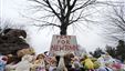 Stuffed animals and a sign calling for prayer rest at the base of a tree near the Newtown Village Cemetery in Newtown, Conn., Dec. 17, 2012. 