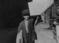 Newsboy holding up newspaper, Denver, Colorado