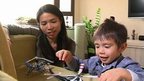 Mother watching her son playing with toy aircraft