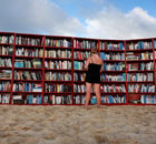 A beach goer selects books from world's longest outdoor bookcase on Bondi Beach, Sydney, Australia