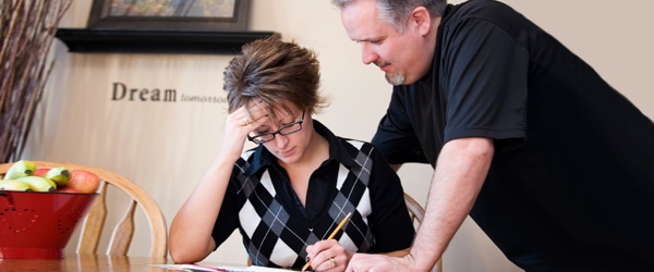 Family seated around a kitchen table writing an emergency plan