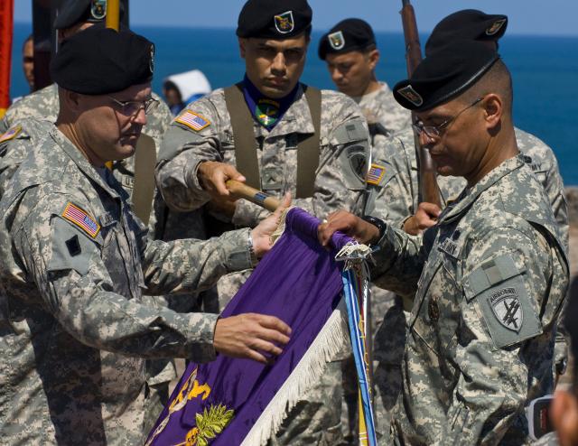 U.S. Army Reserve Lt. Col. Jeffrey Jurasek (left), commander of the 402nd Civil Affairs Battalion, unfurls the unit's colors as Command Sgt. Major Jose A. Torres holds the flagpole at the San Felipe de El Morro castle in the Old San Juan for the unit's re-establishment ceremony on April 4. The unit permanently moved to the island in June 2008 from New York."