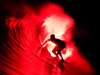 Photo: Bruce Irons rides a surfboard lit with red flares in the Mentawai Islands, Indonesia