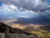 Photo: A paraglider soars in the air above a Tanzanian landscape 