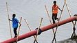 Children use a pipe as a bridge in Bangladesh