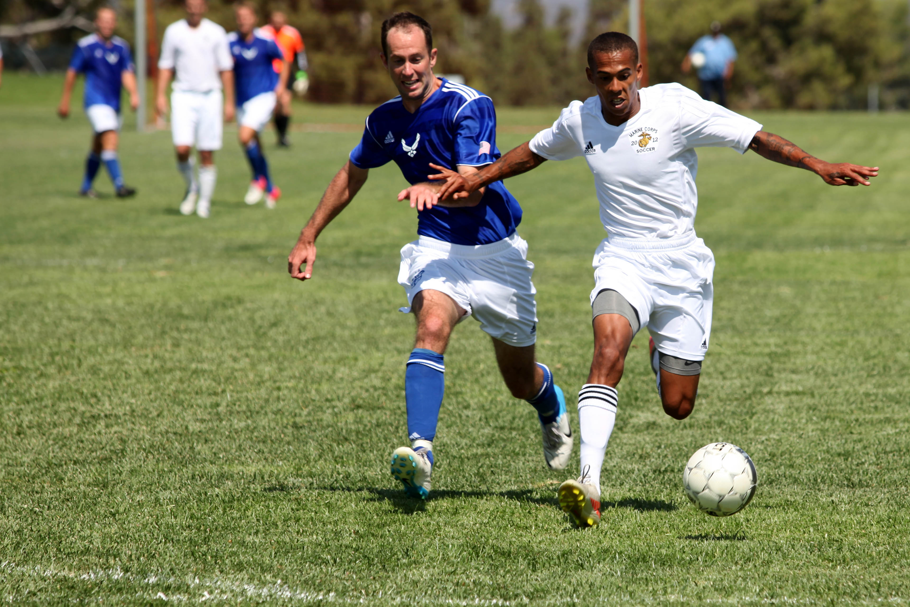 MARINE CORPS BASE CAMP PENDLETON,Calif. -- Cpl. Bryant Haskinjames, a foward for the Marine Corps team, fights off a defender as he dribbles toward the goal during the 2012 Armed Forces Men's Soccer Championship at the 11 Area Parade Deck, Sept. 26. The Air Force team defeated the Marine Corps team 2-1, handing the Marines their first loss of the tournament. (Photo by Lance Cpl. Derrick K. Irions)